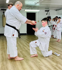 student being awarded higher belt after a grading.